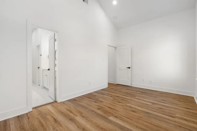 a view of an empty room with wooden floor