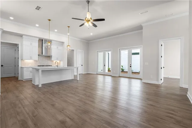a view of an empty room with kitchen view and a window