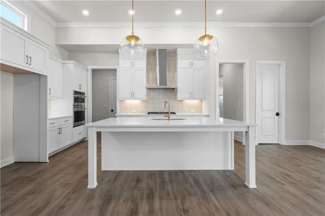 a kitchen with kitchen island white cabinets and stainless steel appliances