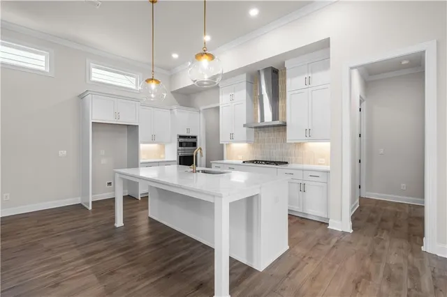 a kitchen with kitchen island granite countertop a sink cabinets and wooden floor