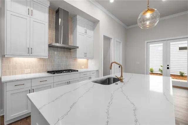 a kitchen with stainless steel appliances granite countertop a stove white cabinets a sink and dishwasher