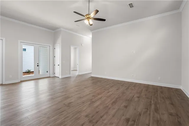 an empty room with wooden floor and ceiling fan