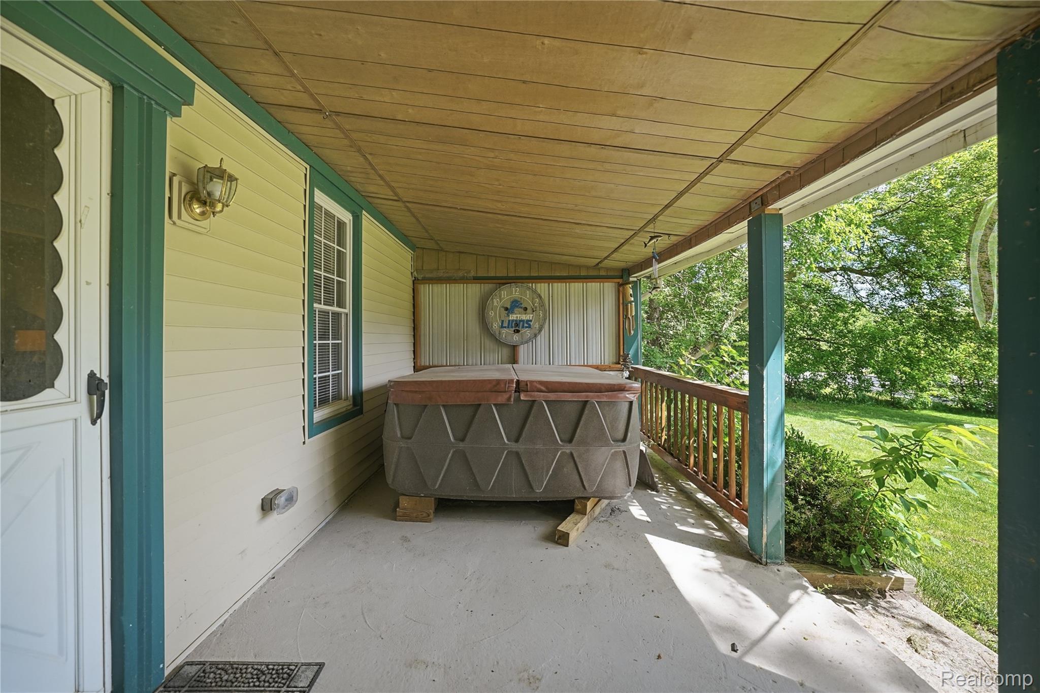 6790 Weyer Road Imlay City, MI 48444 - Photo 28 of 34 Covered porch featuring a hot tub with a protective cover, vinyl siding, a wooden railing, and a slatted wood ceiling