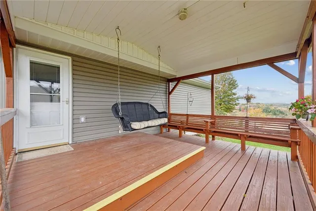 a balcony with wooden floor and outdoor seating