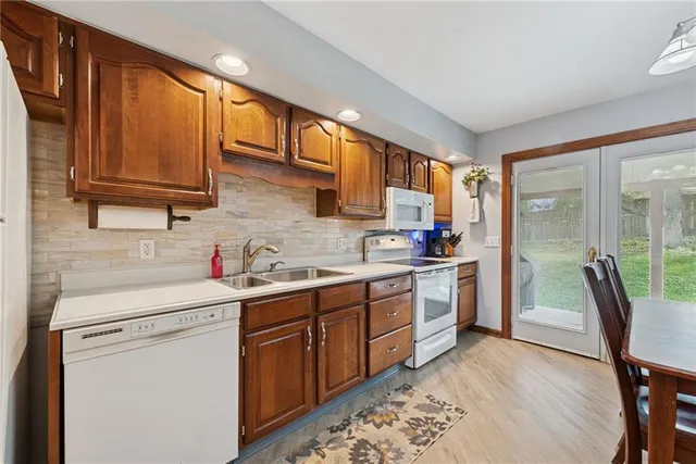 a kitchen with a sink appliances cabinets and furniture