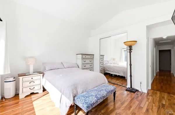 a bedroom with a bed and wooden floor