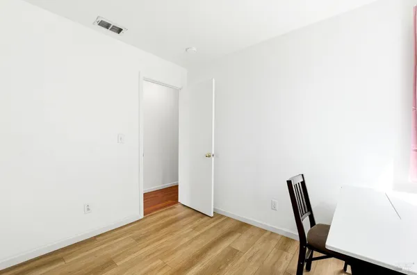 a bed sitting in a bedroom next to a window