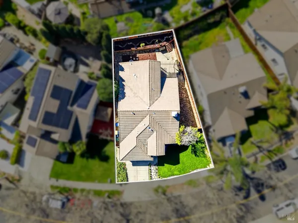 an aerial view of a city with lots of residential buildings ocean and mountain view in back