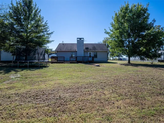 a view of a large pool with a big yard and large trees