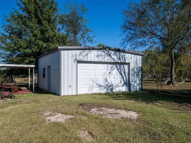 a view of a house with backyard and trees