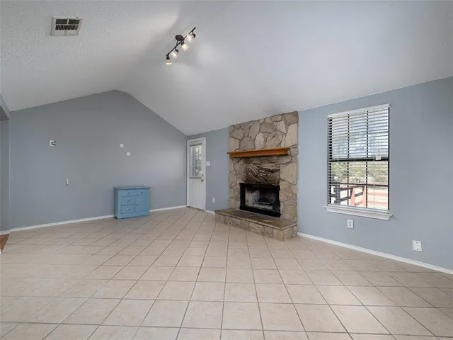 an empty room with windows and fireplace