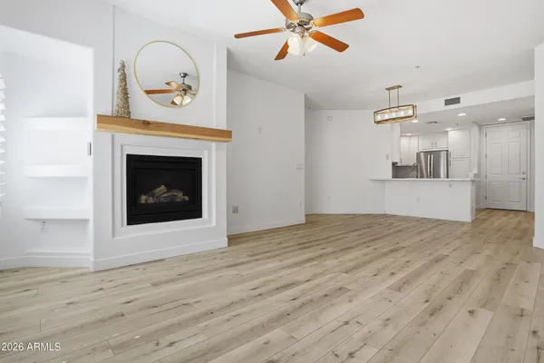 a view of an empty room with a fireplace and wooden floor