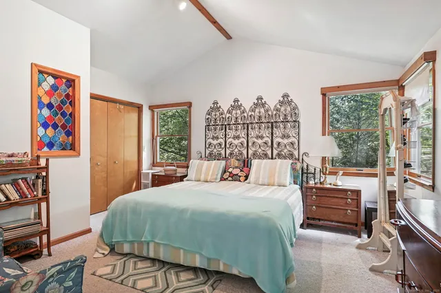 a bedroom with a bed furniture and a large window