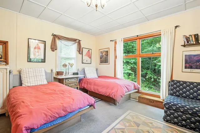 a bedroom with three beds and a window