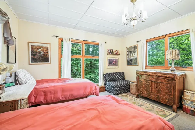 a bedroom with two beds and windows