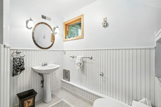 a bathroom with a sink mirror and toilet