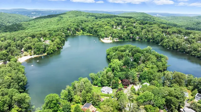 an aerial view of a residential houses with outdoor space and lake view