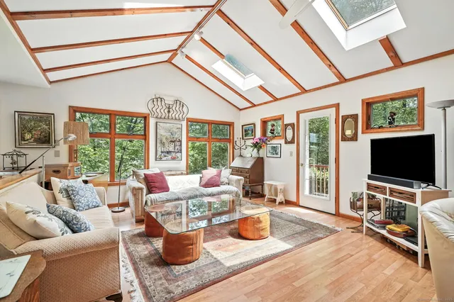 a living room with furniture a flat screen tv and a floor to ceiling window
