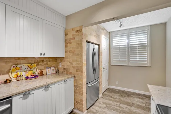 a kitchen with stainless steel appliances granite countertop a refrigerator and a sink