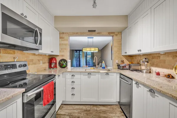 a kitchen with a stove top oven sink and cabinets
