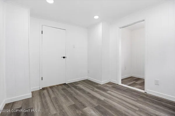 a view of empty room with window and wooden floor