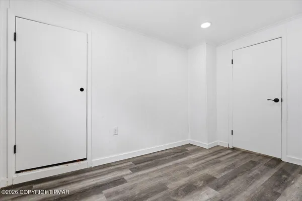 a view of a room with wooden floor and white walls