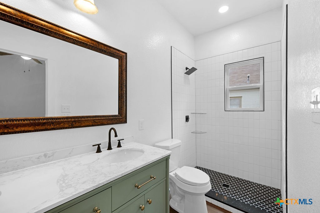 607 West 3rd Street Eddy, TX 76524 - Photo 13 of 29 a bathroom with a granite countertop sink toilet and shower
