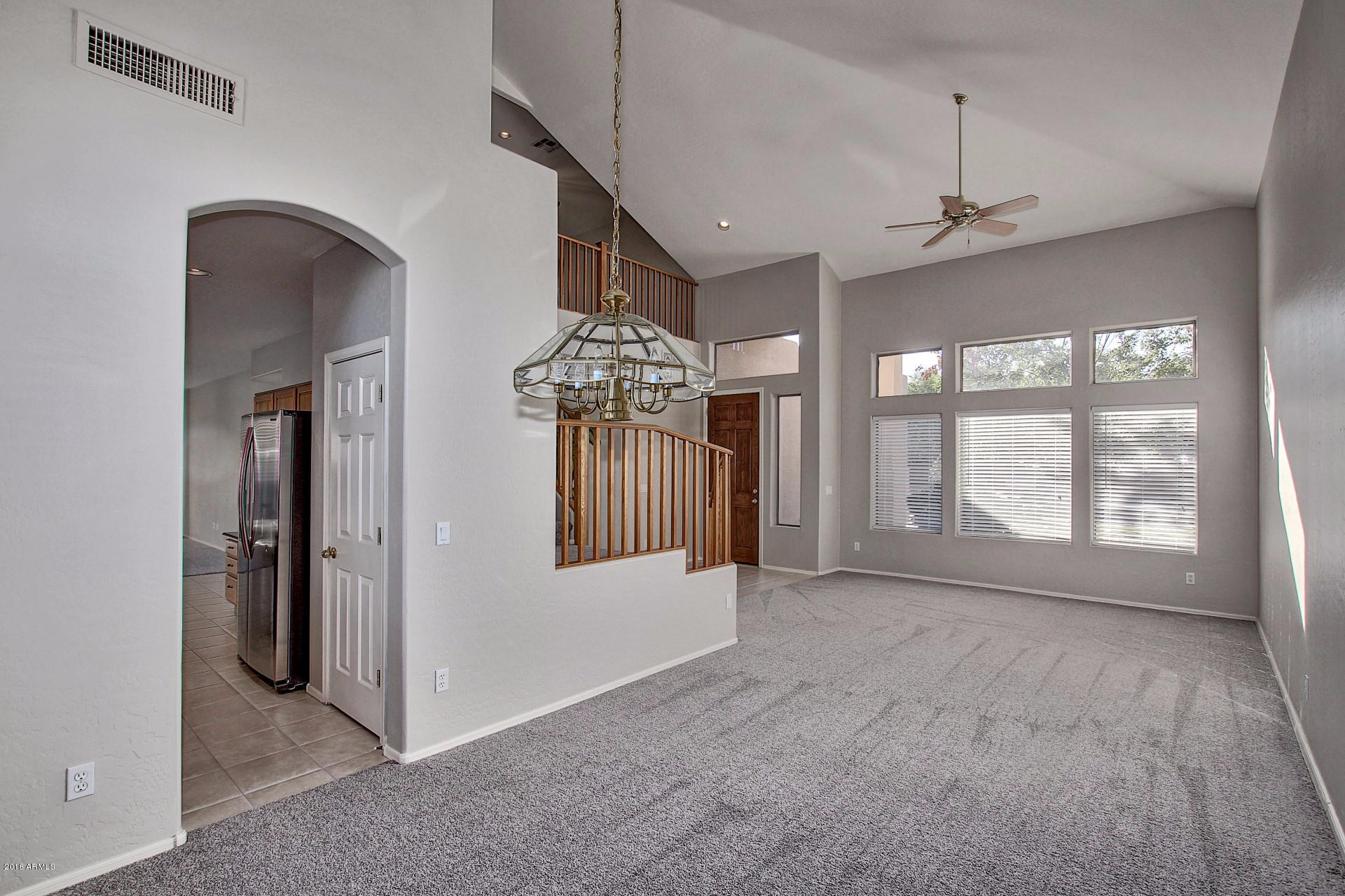 1360 East Harrison Street Gilbert, AZ 85295 - Photo 6 of 34 an empty room with large windows and a chandelier