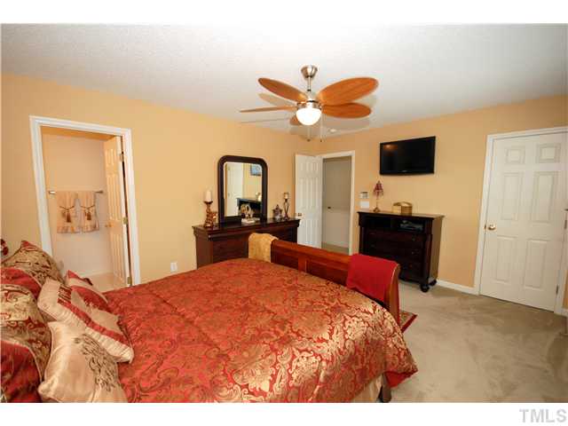 4105 Mantua Way Raleigh, NC 27604 - Photo 16 of 25 a bedroom with a bed and a chandelier