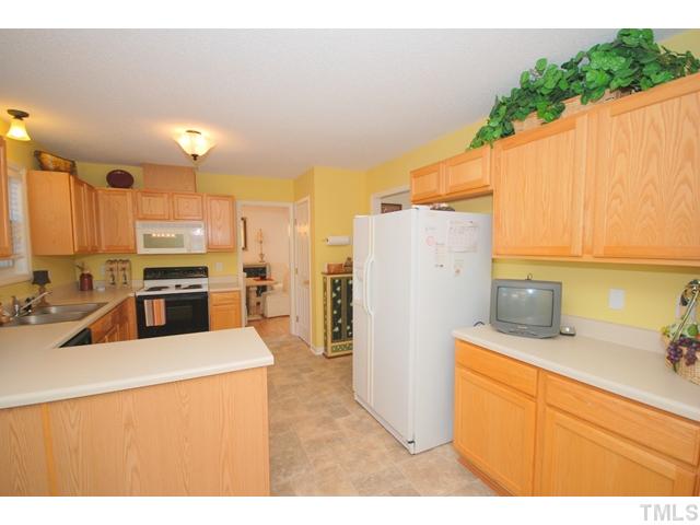 4105 Mantua Way Raleigh, NC 27604 - Photo 10 of 25 a kitchen with a refrigerator a stove top oven a sink and dishwasher