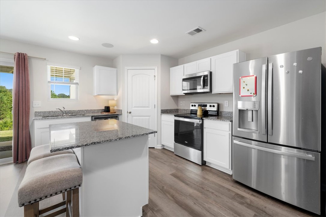 117 Adger Road Pendleton, SC 29670 - Photo 10 of 36 This modern kitchen features gleaming countertops, essential appliances, and an inviting island, perfect for daily living.