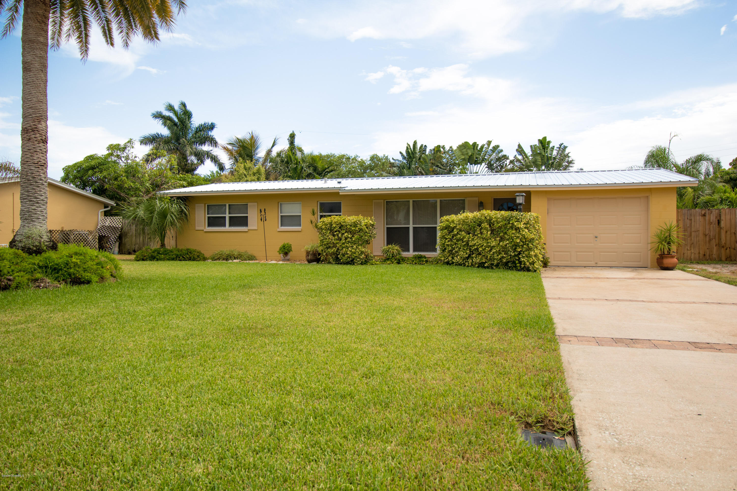 1054 Bali Road Cocoa Beach, FL 32931 - Photo 2 of 24 a front view of house with yard and green space