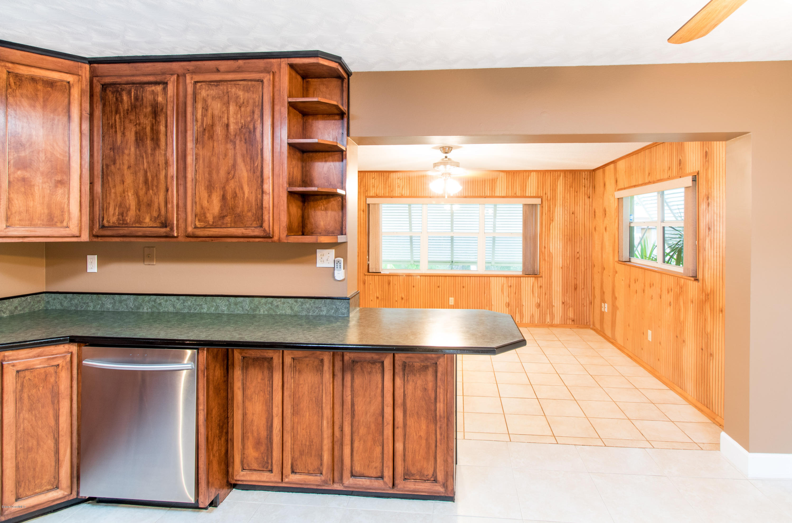 1054 Bali Road Cocoa Beach, FL 32931 - Photo 11 of 24 a kitchen with wooden cabinets and a large window