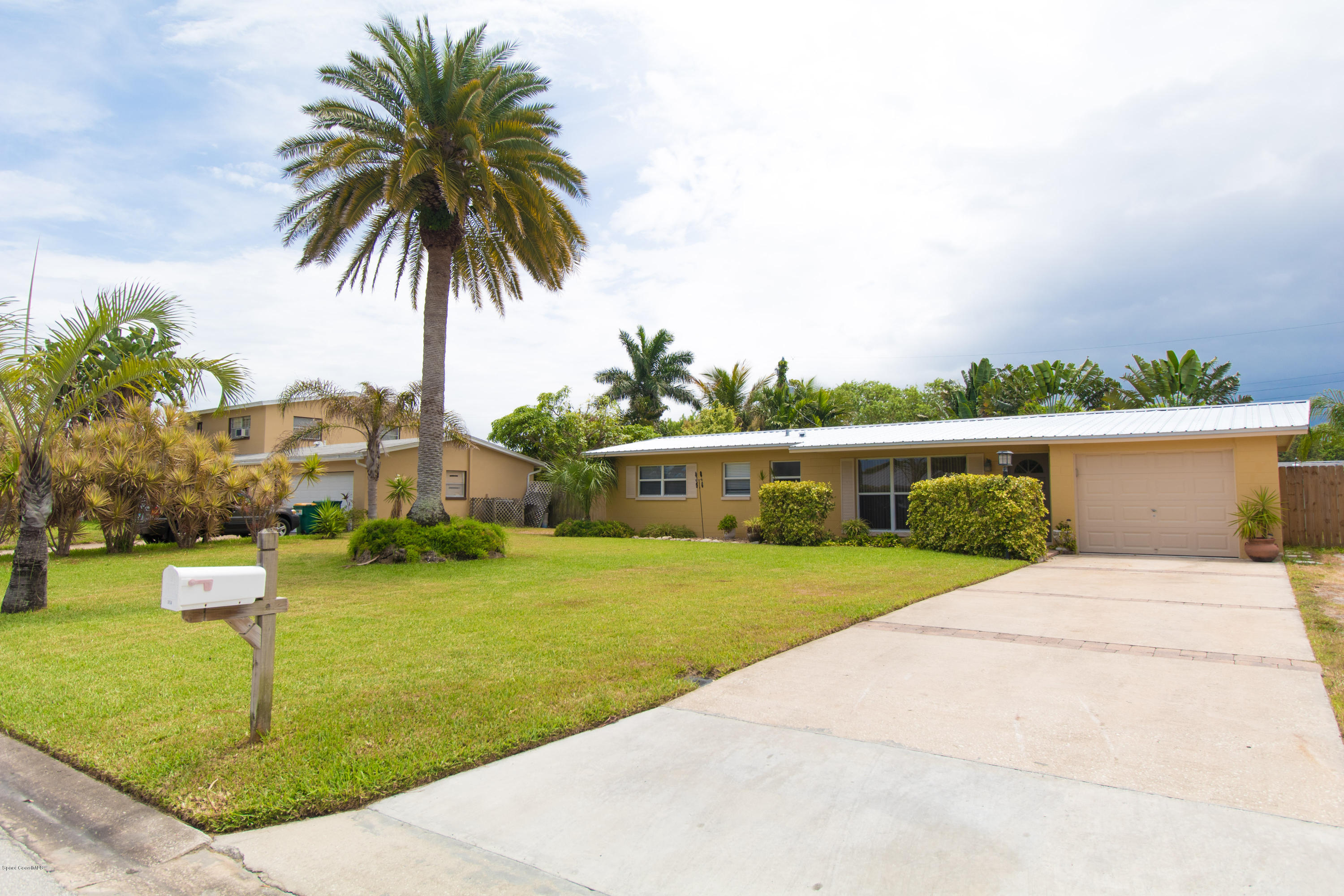 1054 Bali Road Cocoa Beach, FL 32931 - Photo 3 of 24 a front view of a house with garden