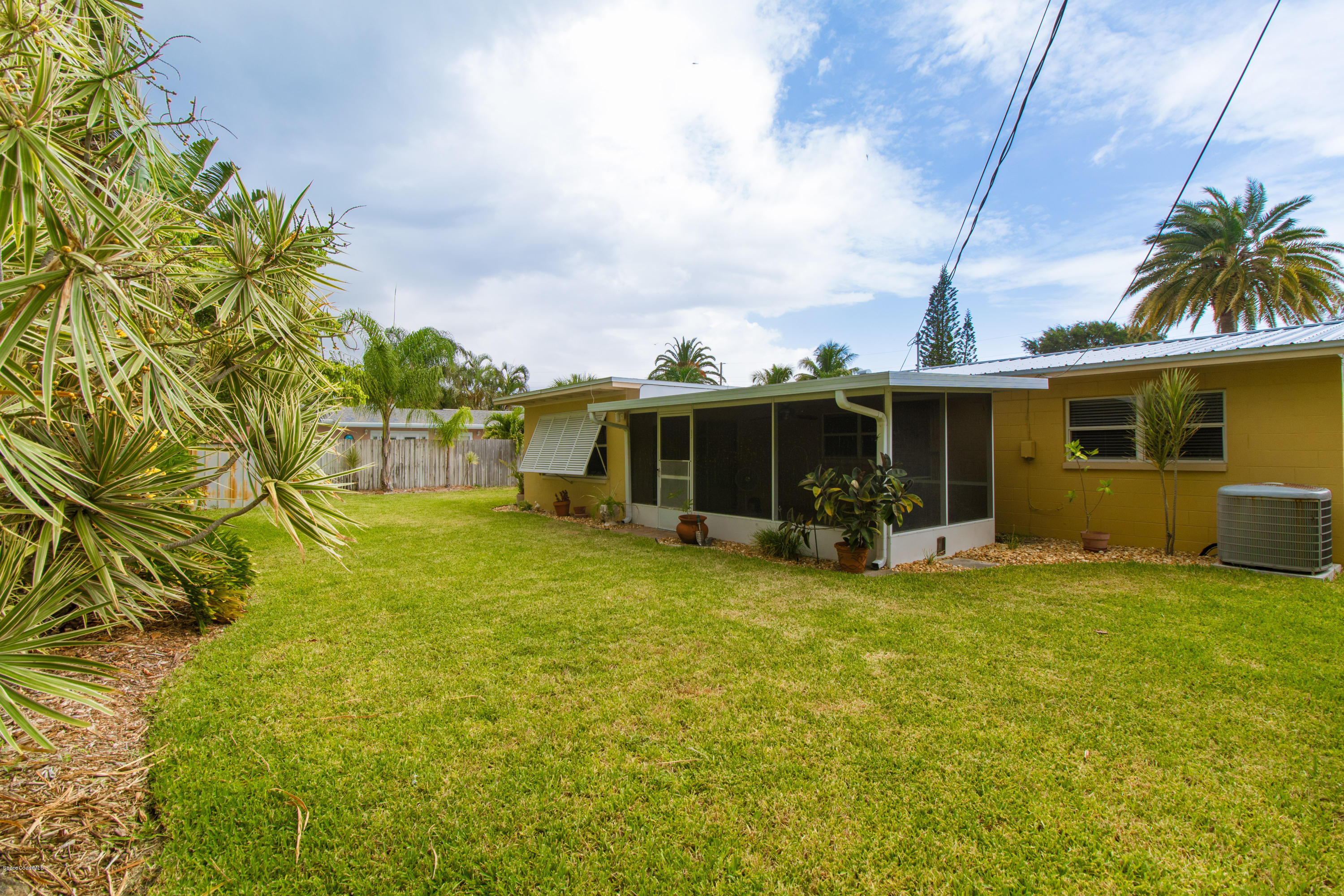 1054 Bali Road Cocoa Beach, FL 32931 - Photo 21 of 24 a view of a house with backyard porch and garden