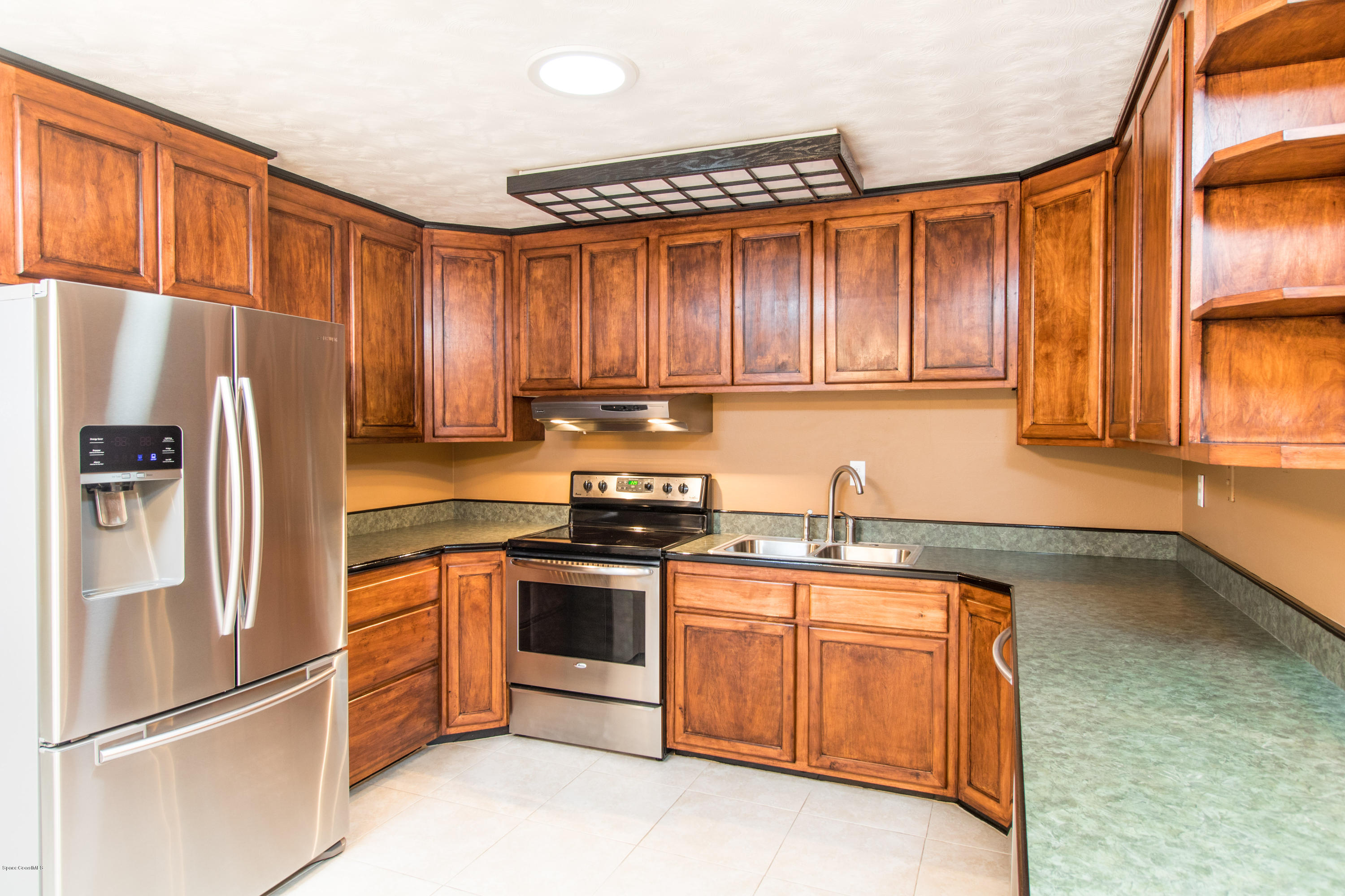 1054 Bali Road Cocoa Beach, FL 32931 - Photo 9 of 24 a kitchen with stainless steel appliances granite countertop a refrigerator stove and sink
