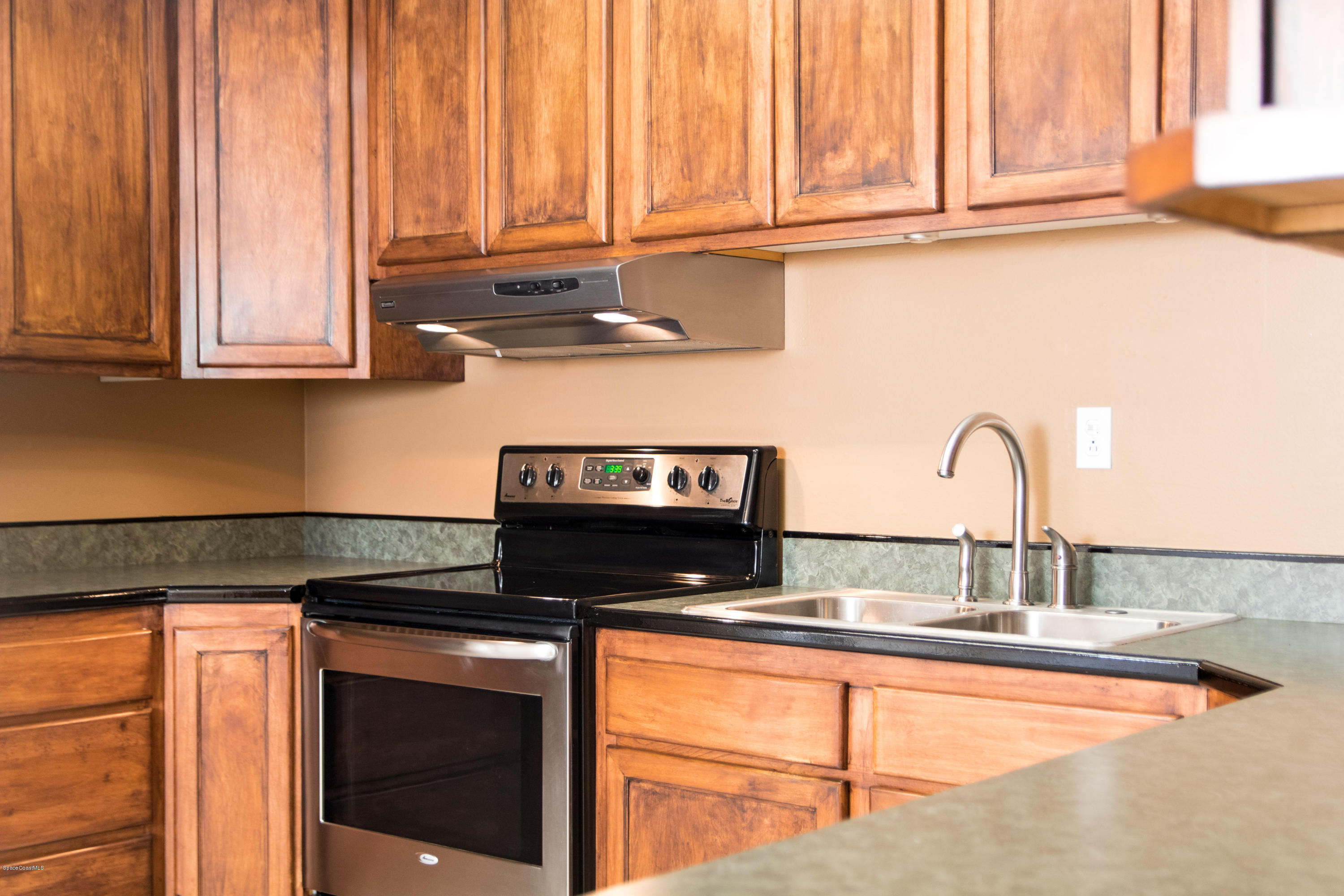 1054 Bali Road Cocoa Beach, FL 32931 - Photo 10 of 24 a kitchen with granite countertop a sink and a stove