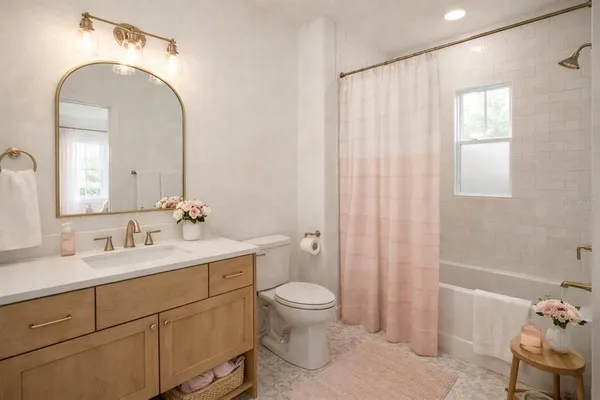 a spacious bathroom with a double vanity sink toilet and a mirror