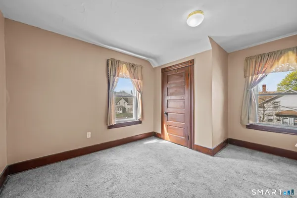 an empty room with windows and closet