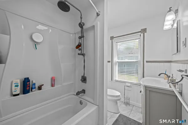 a bathroom with a granite countertop sink a toilet and shower