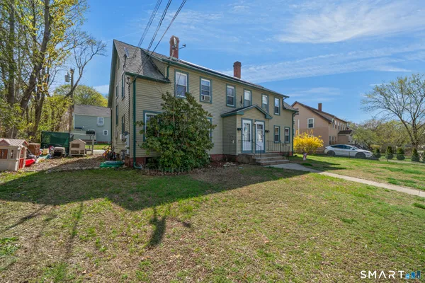 a front view of house with yard and trees