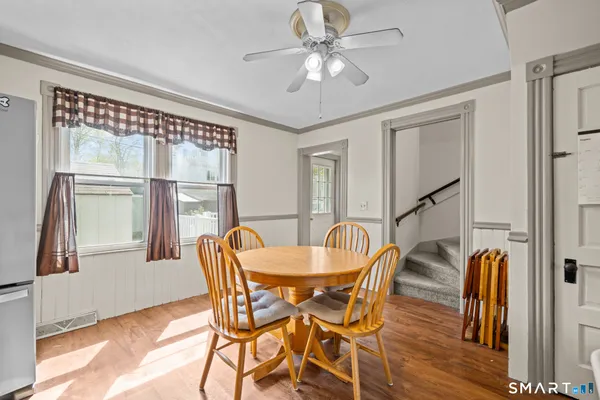 a dining room with furniture a chandelier and wooden floor
