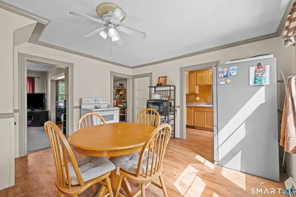a dining room with furniture and chandelier fan