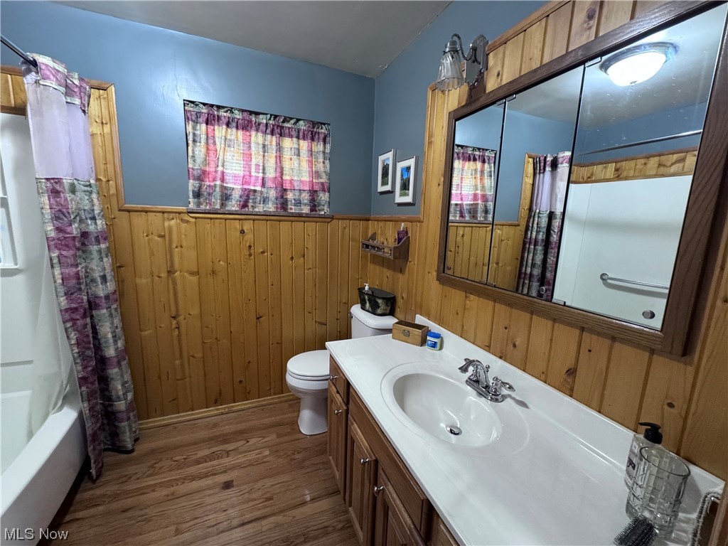2361 Dutch Ridge Road Parkersburg, WV 26104 - Photo 13 of 17 Full bathroom featuring shower / bathtub combination with curtain, vanity with extensive cabinet space, hardwood / wood-style flooring, toilet, and wooden walls