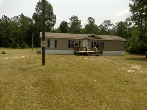 5825 Bush Road Baker, FL 32531 - Photo 1 of 27 a front view of house with yard garage and trees