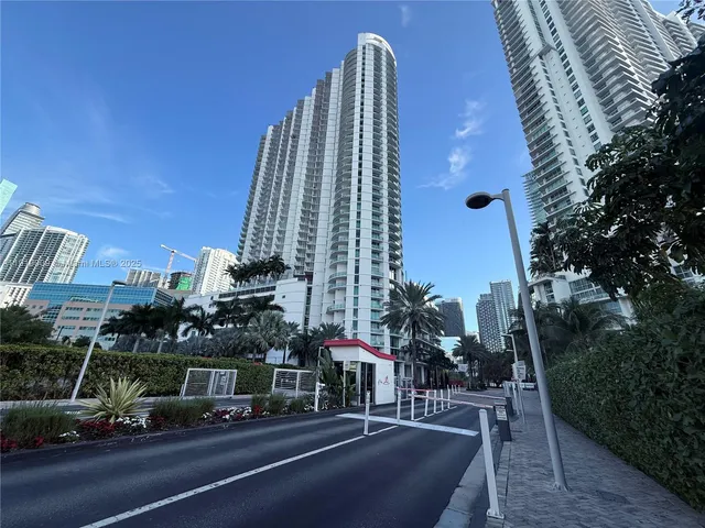 a view of a tall building next to a yard