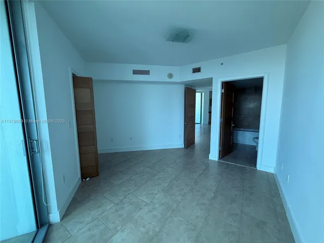 an empty room with closet and mirror