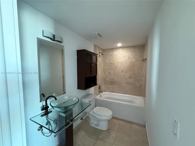 a bathroom with a toilet a sink and shower