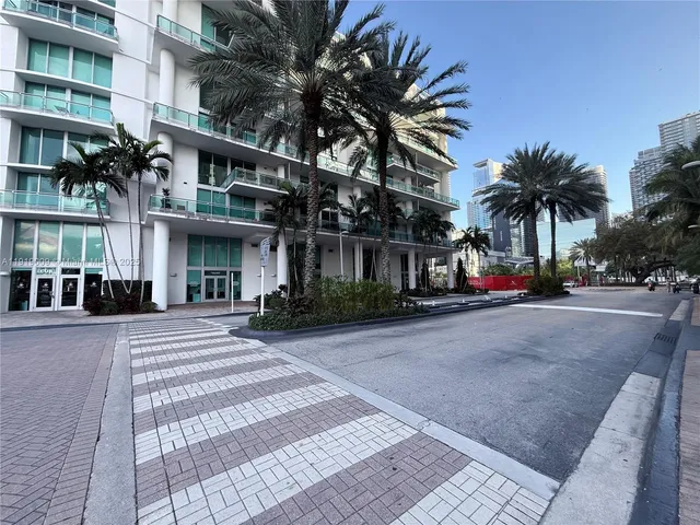 a view of a building with a yard and palm trees