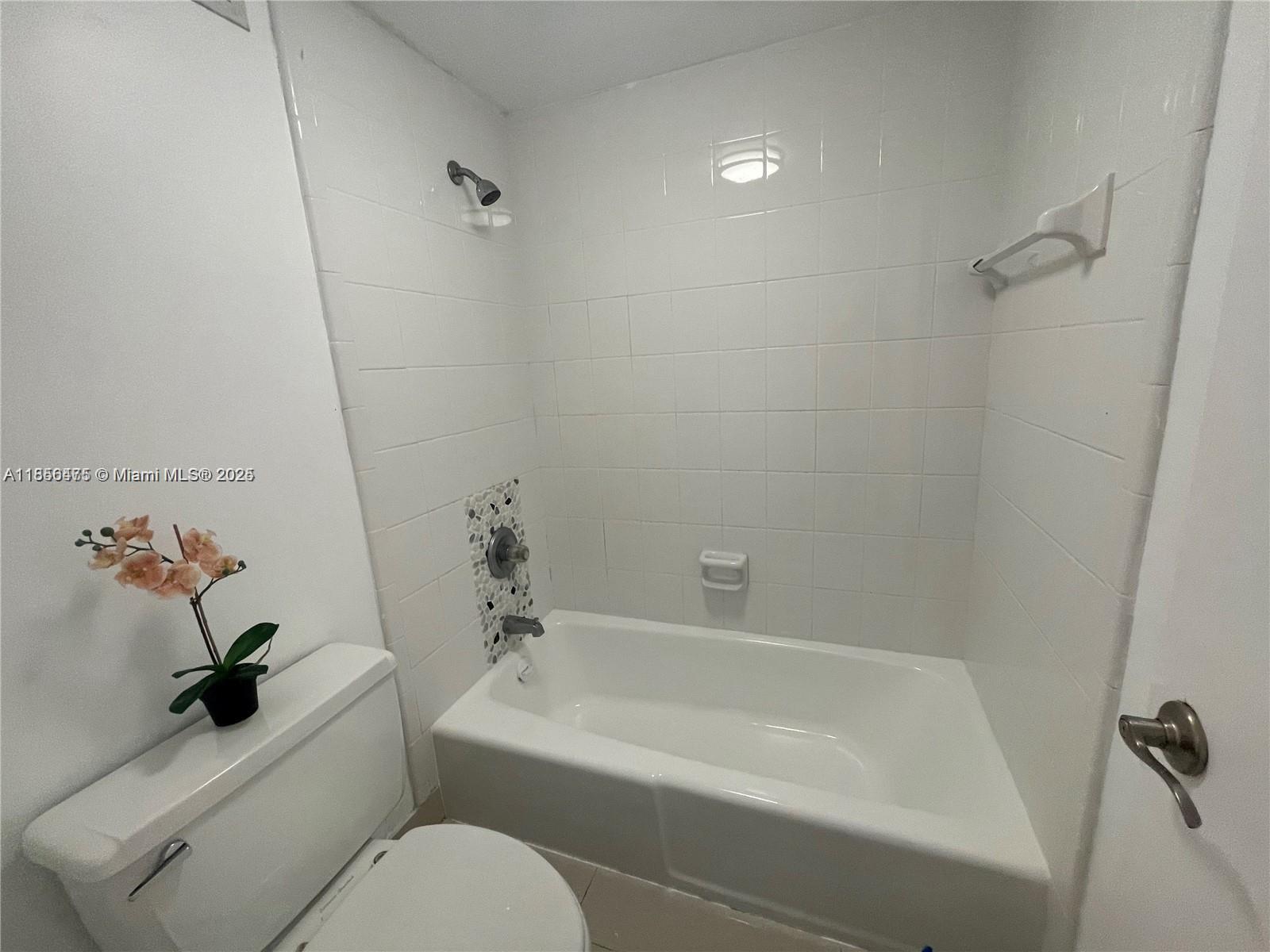 2899 Collins Avenue, Unit 1420 Miami Beach, FL 33140 - Photo 11 of 17 a bathroom with a toilet and a bathtub